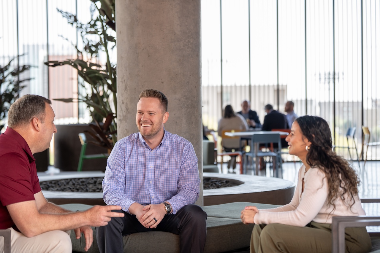 Executive MBA graduate Jack Schannep talks to two other people while sitting in McCord Hall on the ASU campus
